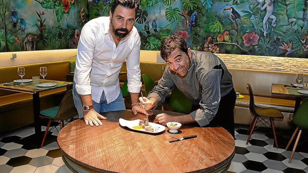 David Álvarez y Óscar Ferrández, en el comedor de Atípico donde está la obra de Sonia Abrain.