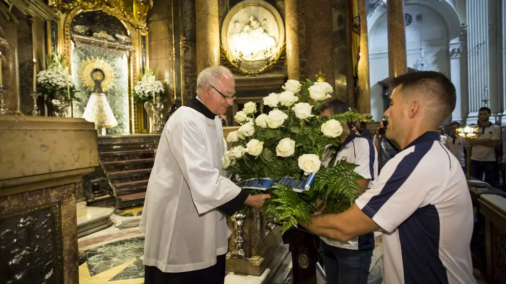 Los jugadores entregan el centro al párroco, ayer en la Catedral-Basílica del Pilar.