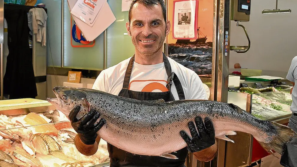 Alberto Lallana, de Pescados Cañete, en el Mercado de San Vicente de Paúl de Zaragoza, con un bonito ejemplar de salmón.