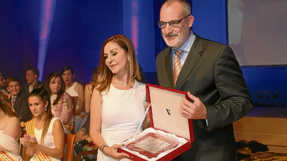 La periodista María García, pregonera, recibe la placa de manos del alcalde Álvaro Burrell.