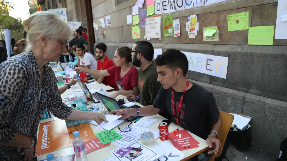 Universitarios montan en Barcelona una mesa informativa sobre el referéndum soberanista.