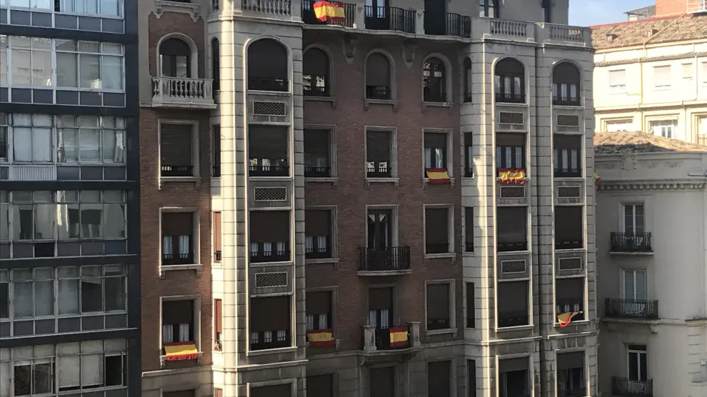 Imagen de varios balcones en el centro de Zaragoza con la bandera de España.