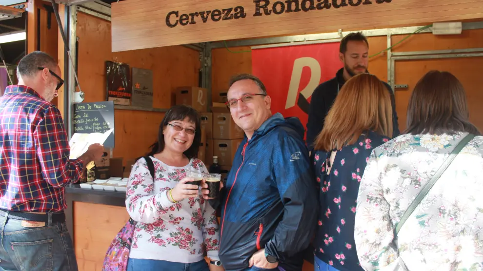 Dos vecinos de la capital aragonesa brindan con cerveza Rondadora en la Muestra de Artesanía Alimentaria de la plaza de los Sitios.