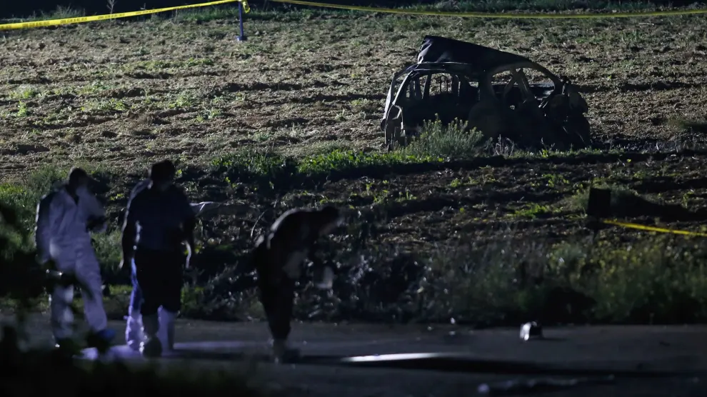 Los forenses revisan el lugar donde explotó el vehículo de la periodista.