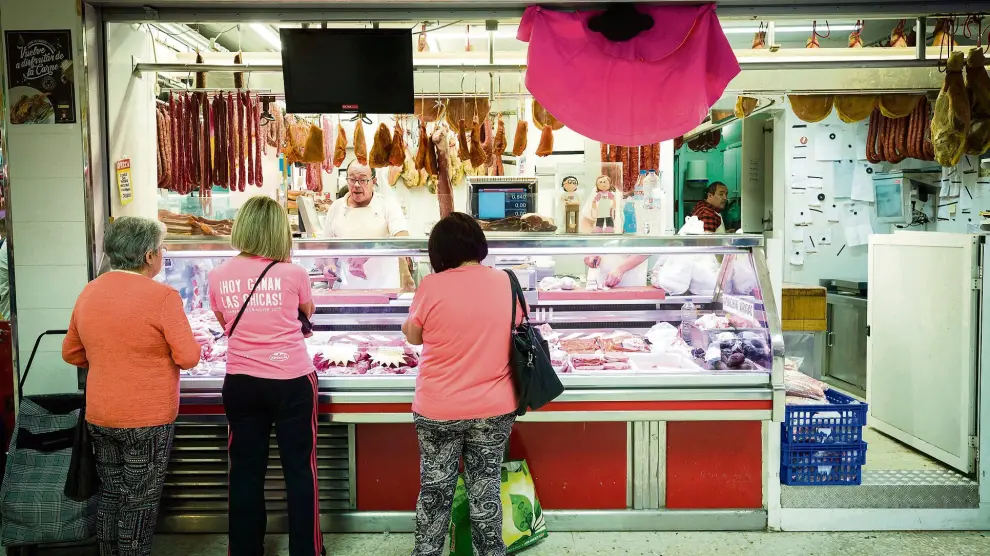El puesto del carnicero José Luis Tris, en el mercado de Puerta Sancho, está estos días bien surtido de carne de toro de lidia y decorado con un vistoso capote.