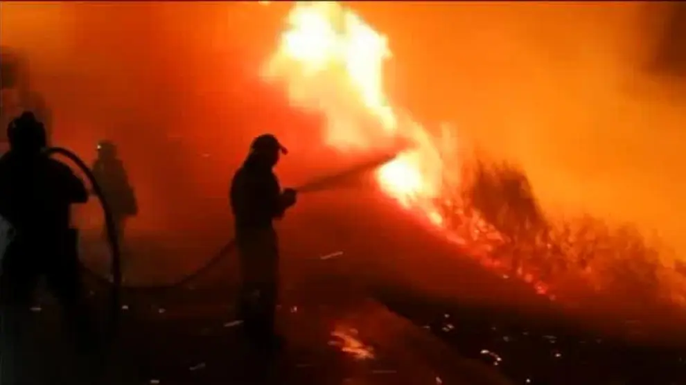 Los bomberos trabajan para alejar el fuego de la reserva de Muniellos