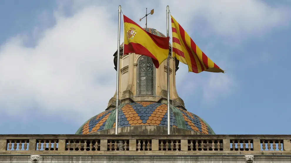 Las banderas española y catalana ondean en la fachada del edificio de la Generalitat en la plaza San Jaume de Barcelona.