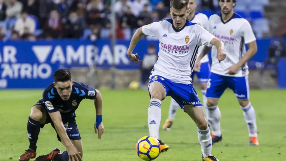 Febas pelea un balón con Isaac en el último partido del Real Zaragoza ante la Leonesa, ante la mirada de Eguaras.
