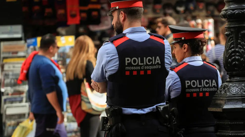 Dos mossos velan por la seguridad en una calle de Barcelona, este sábado.