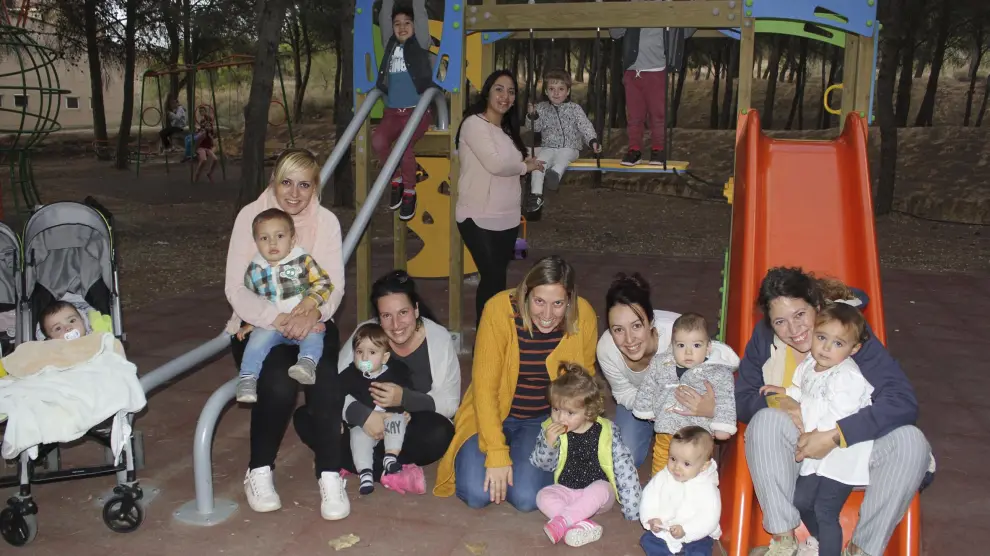 Niños y madres posan en el parque infantil de Sodeto, donde ha repuntado la natalidad.