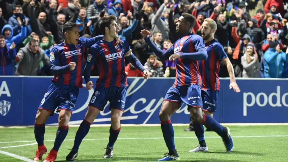 Los jugadores del Huesca, eufóricos, celebran el primer gol ante el Real Zaragoza.