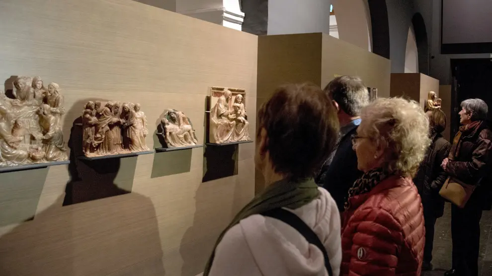 Varios visitantes admirando las obras de Sijena expuestas en el Museo de Lérida.