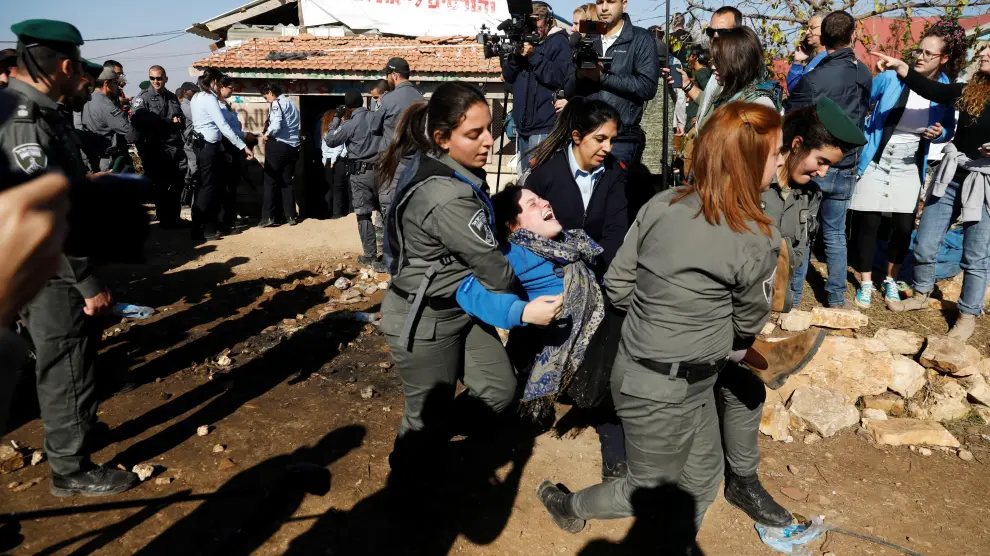 La policía israelí desaloja a una mujer de una de las estructuras de Netiv Haavot, la cual debe ser demolida antes de marzo de 2018