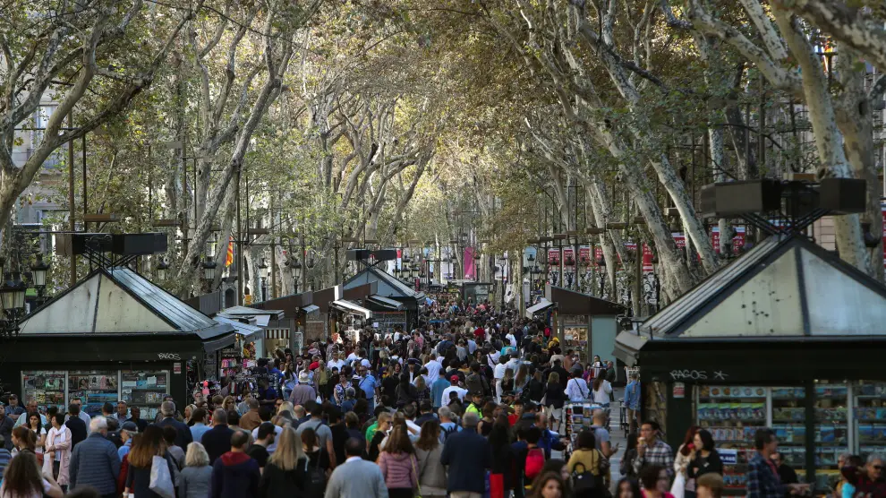 Turistas y visitantes en La Rambla de Barcelona.