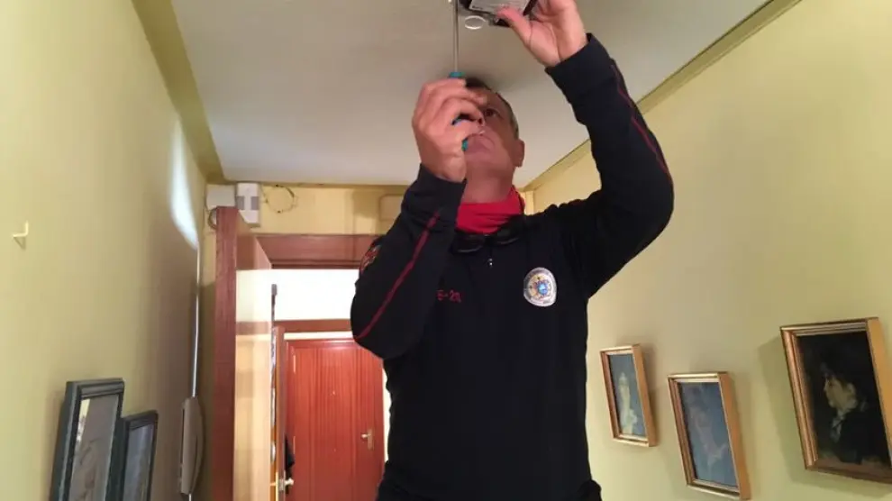 Instalación de un detector de humo en una de las casas