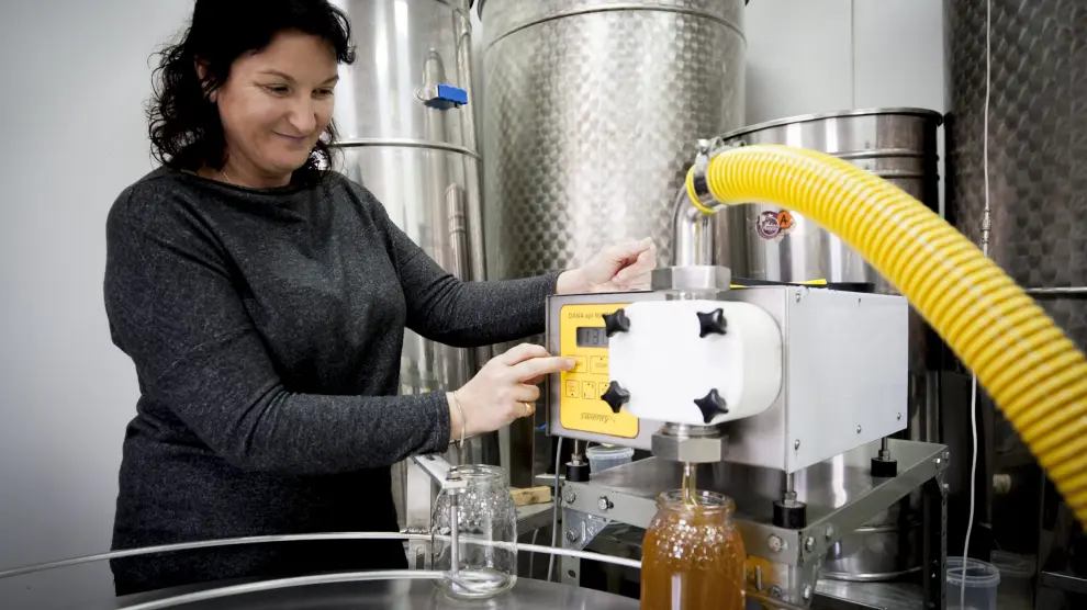 Mari Carmen Sancho envasa un tarro de kilo de miel en el obrador de Peñas Blancas.
