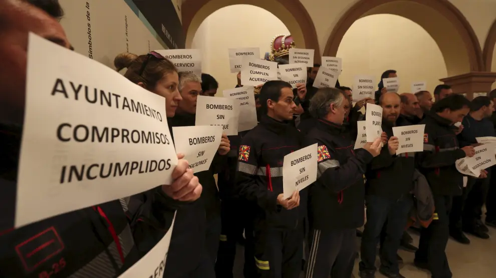 Bomberos y policías locales se concentraron en el vestíbulo del salón de plenos del Ayuntamiento de Huesca.