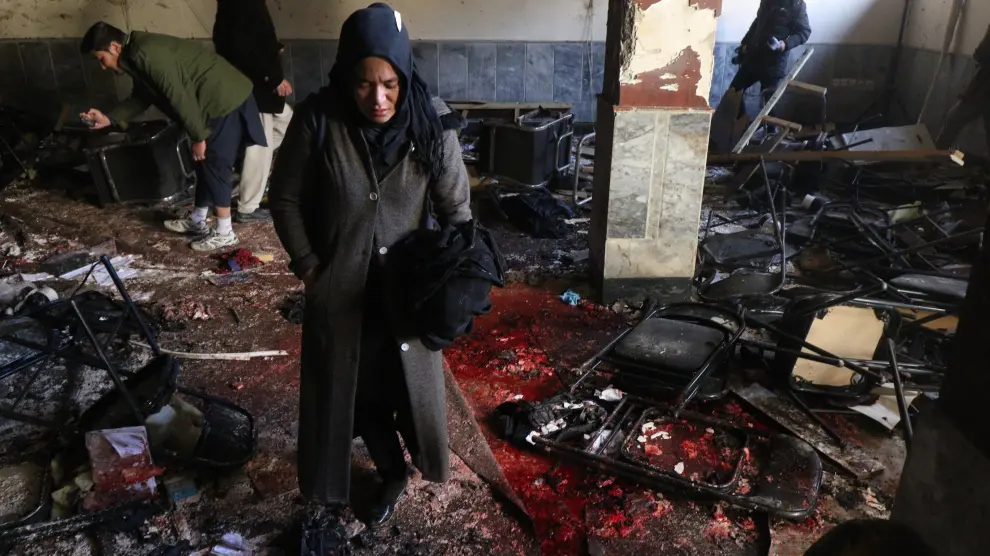Una mujer afgana sobre los destrozos causados en el atentado al centro cultural