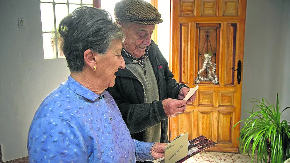 Justiniano Sancho y Natividad Sancho observan unas fotografías antiguas en Torrelapaja.