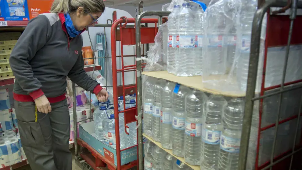La empleada de un supermercado de Calatorao repone botellas y garrafas.