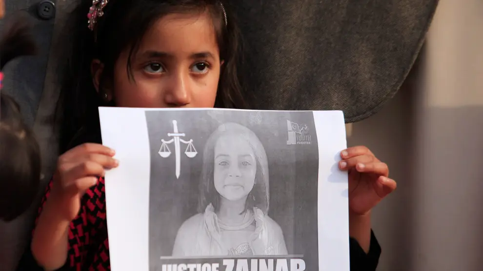 Una niña sujeta la foto de Zainab Ansari, la niña asesinada