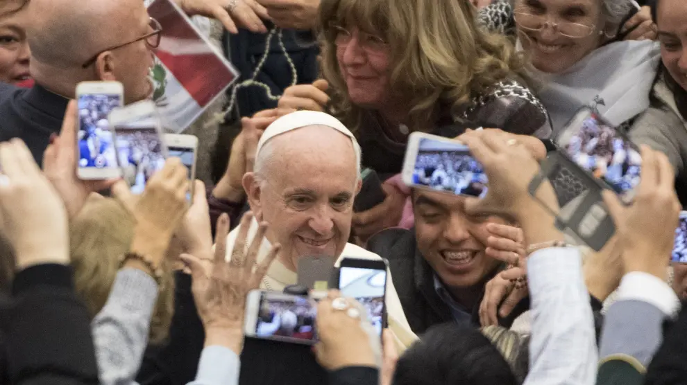 El papa Francisco saluda a las personas que asistieron a su audiencia semanal en el Vaticano.