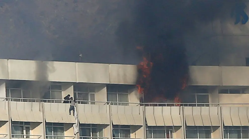 Un hombre trata de escapar del hotel Intercontinental de Kabul atacado.