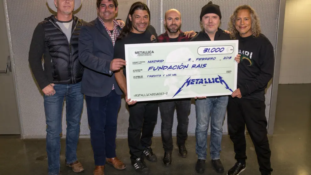 Los integrantes de Metallica posando con el cheque de la donación en Madrid.