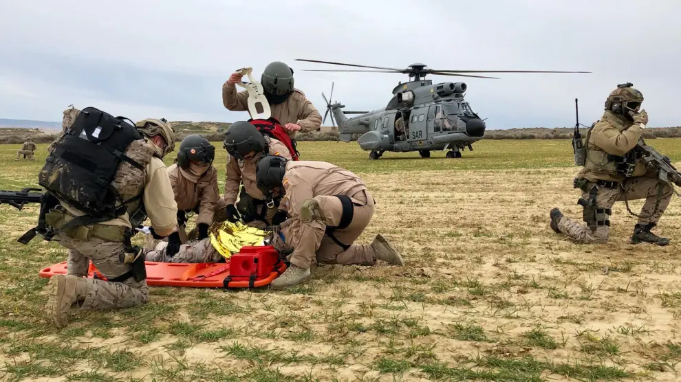 Un grupo de militares rescatan a un herido que trasladan en helicóptero hasta la base de Zaragoza para que lo atiendan en la Unidad Médica de Apoyo al Despliegue.