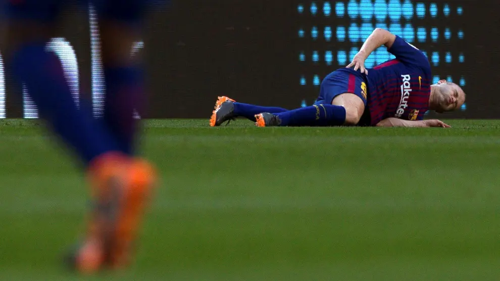Iniesta en el suelo, lesionado durante el partido contra el Atlético de Madrid