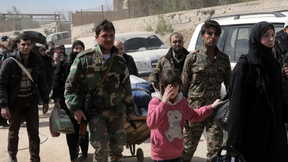 Soldados ayudan a que salgan sirios de Guta Oriental, este jueves, 15 de marzo.