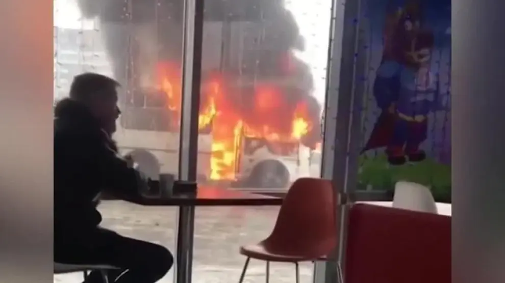 Toma tranquilo su café mientras observa un autobús ardiendo