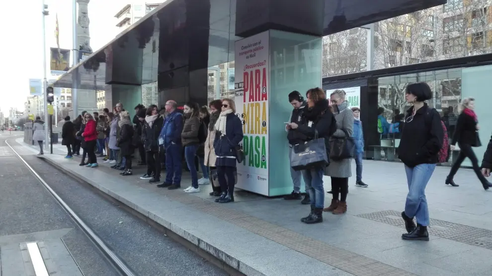Varios ciudadanos esperando el tranvía este martes en el centro de Zaragoza.