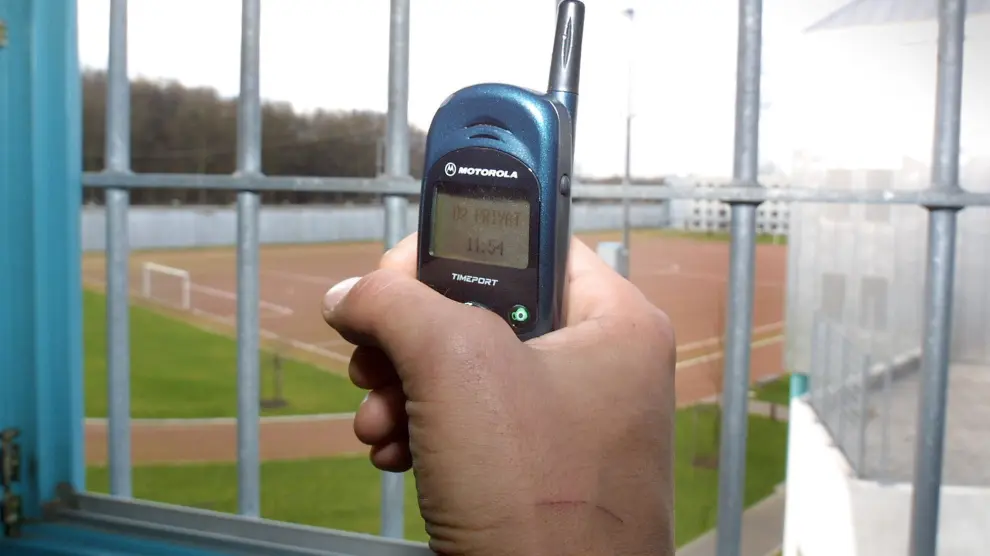 Un preso muestra un teléfono móvil dentro de una celda de una cárcel alemana.