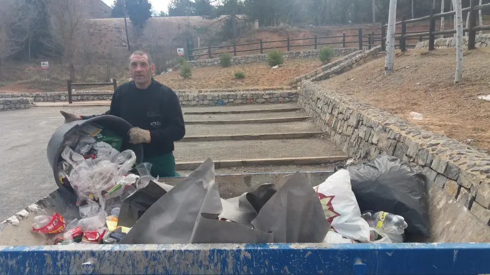 Un trabajador de Atadi recoge la basura desperdigada por Fuente Cerrada.