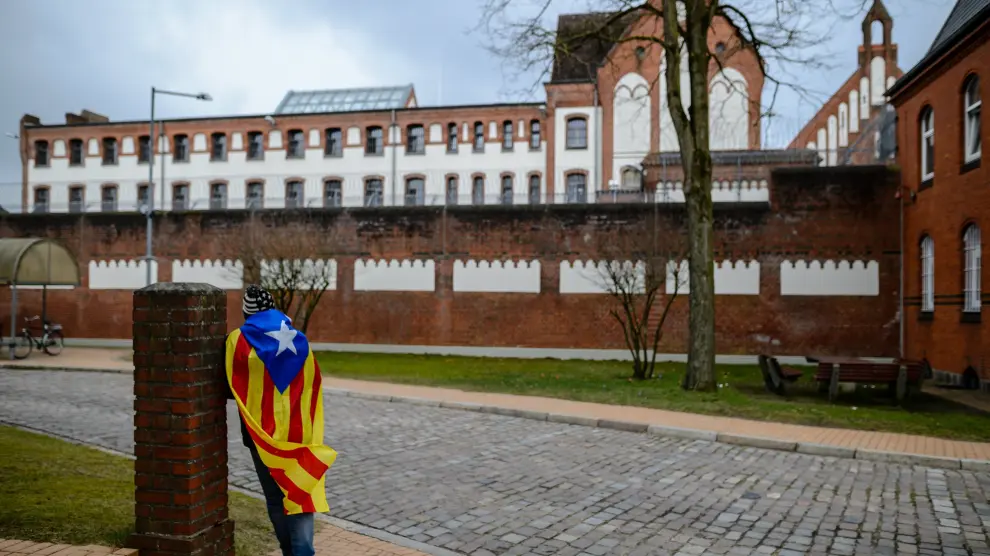Un hombre con una bandera estelada permanece ante la cárcel de Neumünster, donde permanece recluido el expresidente catalán Carles Puigdemont.