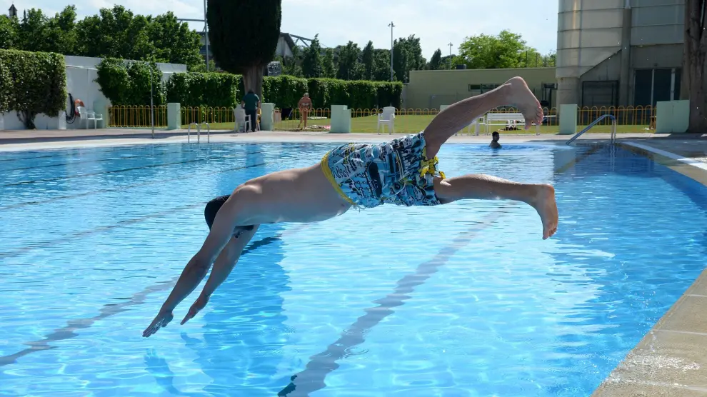 Un bañista se dispone a zambullirse en la piscina del complejo deportivo San Jorge de Huesca.
