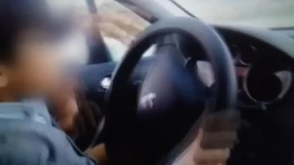 Un niño de 7 años conduce un coche mientras sus padres lo graban