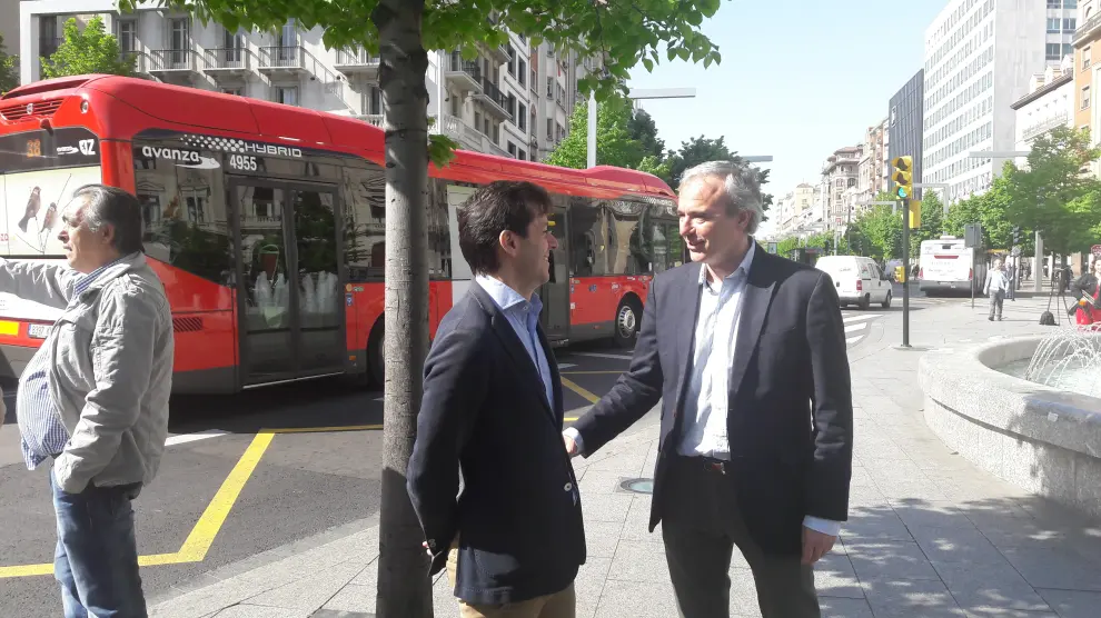 El portavoz del PP, Jorge Azcón, conversa este viernes con el edil de su grupo Sebastián Contín, en la parada del autobús de la plaza de España.