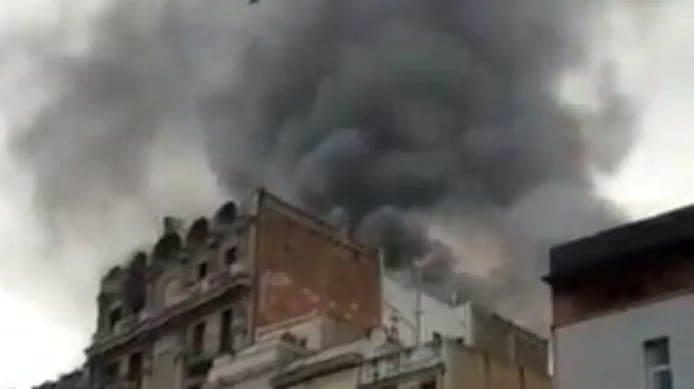Imagen de la columna de humo provocada por el incendio en un piso del Raval, en Barcelona.