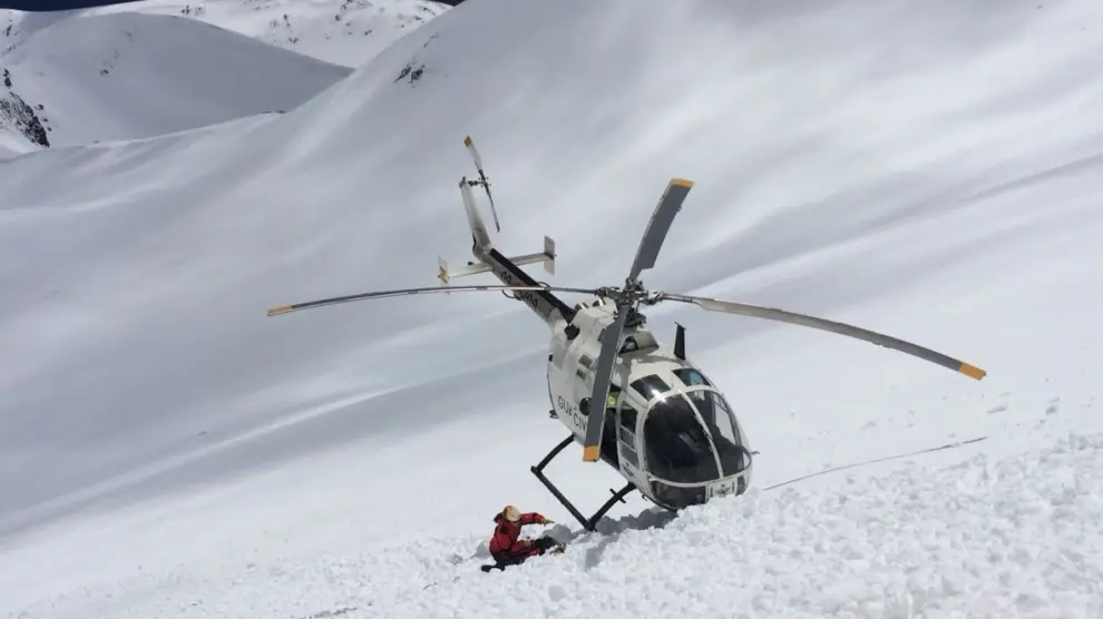 El helicóptero, recogiendo a los esquiadores de montaña arrastrados por el alud