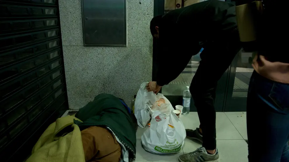 Un voluntario deja comida a una persona en un cajero.