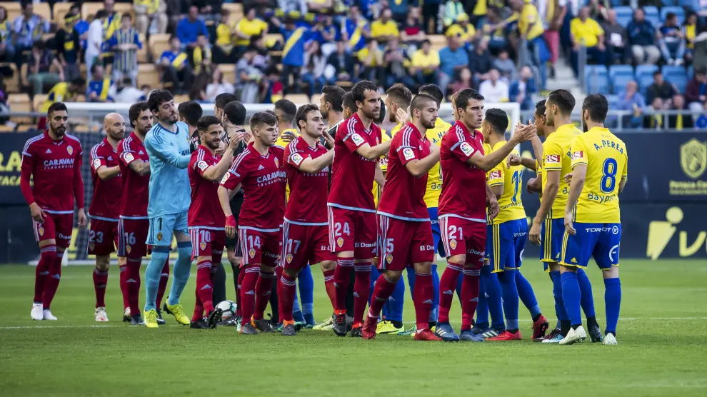 Los jugadores del Real Zaragoza y del Cádiz se saludan al comienzo del partido.