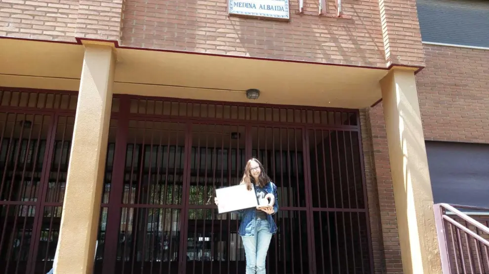 La zaragozana Estela Bescós, alumna del IES Medina Albaida de Zaragoza, posa con su diploma y el trofeo a las puertas del centro.