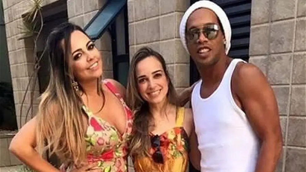 Ronaldinho posando con las dos mujeres con las que mantiene una relación.