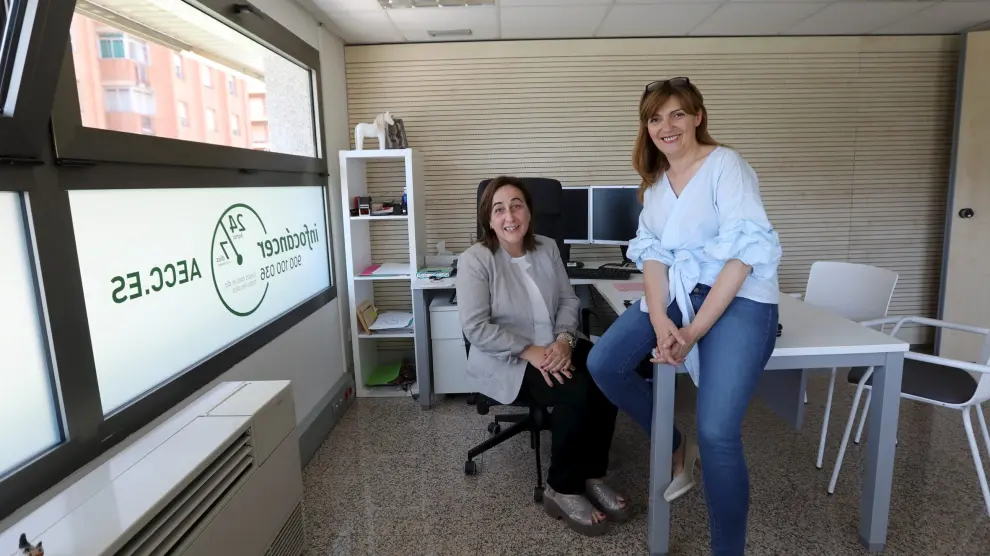 La presidenta de la AECC en Huesca, Aurora Calvo, y la psicóloga Ana Palomera en la nueva sede.