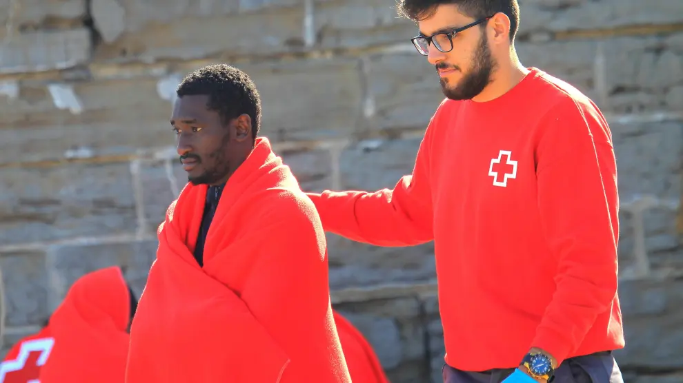 Un voluntario de la Cruz Roja acompaña a un inmigrante en el Estrecho de Gibraltar