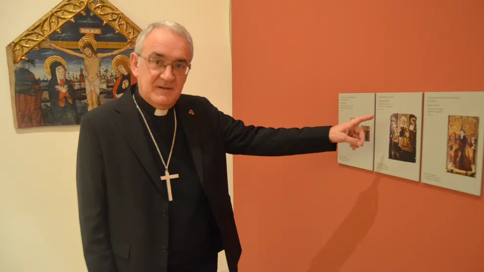 El obispo Ángel Pérez muestra varias de las fotos de bienes reclamados en el Museo de Barbastro.