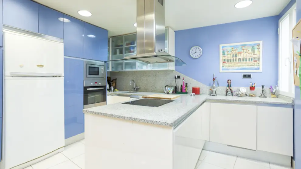 La cocina es una de las estancias más llamativas de la casa, por el color azul que reina en ella y su impresionante pared de cristal.