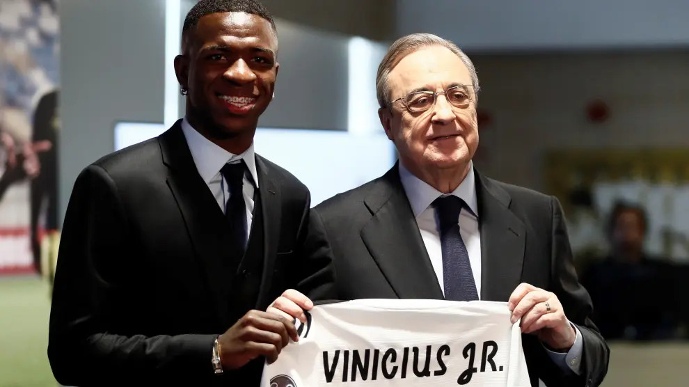 Vinicius Junior sujeta su nueva camiseta, sin dorsal, junto al presidente Florentino Pérez